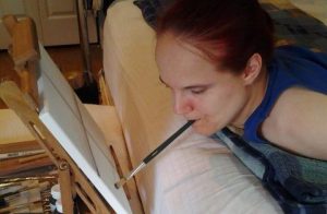 Disabled artist painting on canvas.